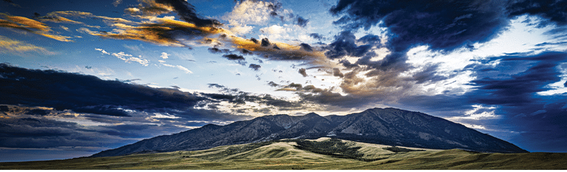 A mountain range with a cloudy sky above it. AI generated content