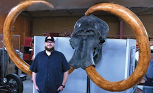 A man is standing next to a large wooden bull head, which is on display. AI generated content